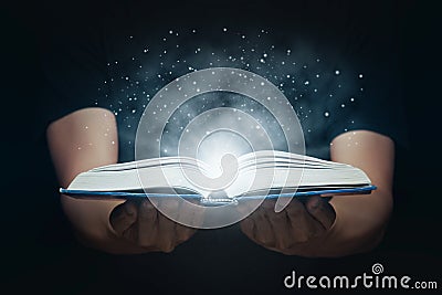 Man open magic book with growing lights and magic powder floating on the book, Learning, Education, Knowledge and religion Stock Photo