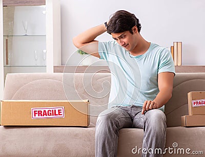 Man opening fragile parcel ordered from internet Stock Photo