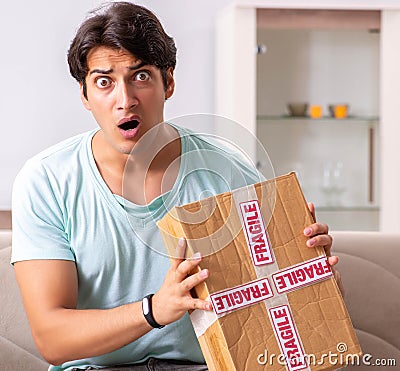 Man opening fragile parcel ordered from internet Stock Photo