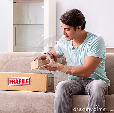 Man opening fragile parcel ordered from internet Stock Photo