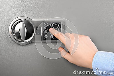 Man opening steel safe with electronic combination lock Stock Photo