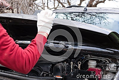 a man opens the hood of a car for repairs. Car repair and maintenance Stock Photo