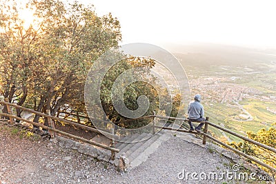 Man Overlooking Beautiful Scenery On Bench Of Mountain Stock Photo