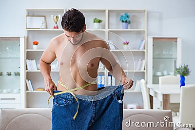 The man in oversized pants in weight loss concept Stock Photo