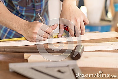 man owner a small furniture business is preparing wood for production. carpenter male is adjust wood to the desired size. Stock Photo