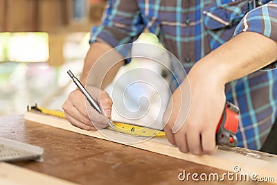 man owner a small furniture business is preparing wood for production. carpenter male is adjust wood to the desired size. Stock Photo