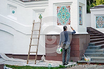 A man paints Assumption church facade. Editorial Stock Photo