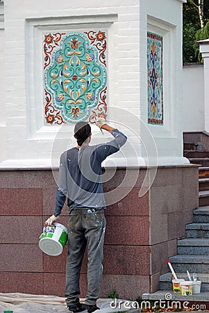 A man paints Assumption church facade. Editorial Stock Photo