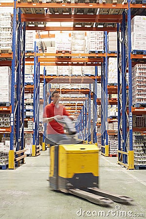 Man With Pallet Jack Through Warehouse Stock Photo