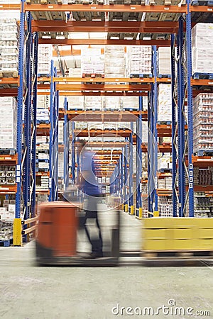 Man With Pallet Jack Through Warehouse Stock Photo