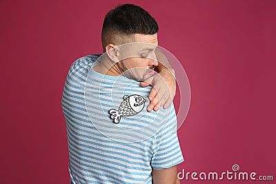 Man with paper fish on back against background. April fool`s day Stock Photo