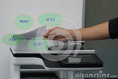 Man with paper on multi functional printer to print, scan, copy and fax in office Stock Photo