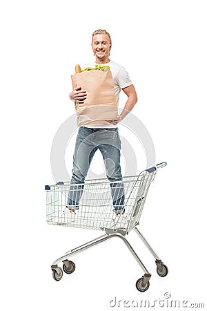 young caucasian man with paper bag standing in shopping cart Stock Photo