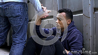 Man passing by, offering helping hand to street child, kindness and charity Stock Photo