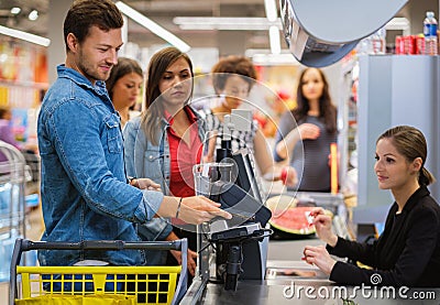 Man paying with NFC in a grocery store Stock Photo