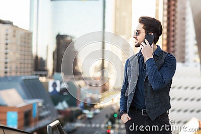 A man on the phone: strategical phone call on the balcony overlooking busy financial city center. Stock Photo