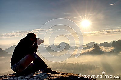 Man photographer hike. Photographer taking photos outdoor by dslr camera. Travel lifestyle Stock Photo