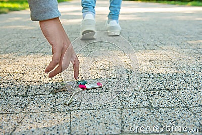 Man picking lost keys from ground, closeup. Space for text Stock Photo