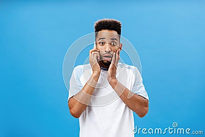 Man picking up phone hearing terrible news feeling shocked and worried holding smartphone near ear opening mouth Stock Photo