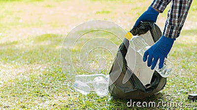 Man picking up plastic bottles, picking up trash in the world, cleaning the forest in the park. to preserve the charity environmen Stock Photo