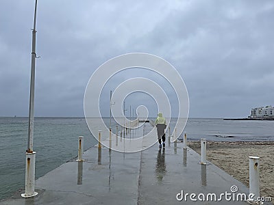 Man on a pier on a rainy day Stock Photo