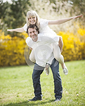 Man piggybacking woman in park Stock Photo