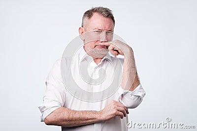 Man pinches nose with finger looks with disgust something stinks bad smell Stock Photo
