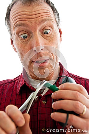 Man pinching a PS2 plug with pliers Stock Photo