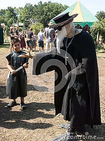 A man in plague doctor costume and a boy at Renaissance Festival Editorial Stock Photo