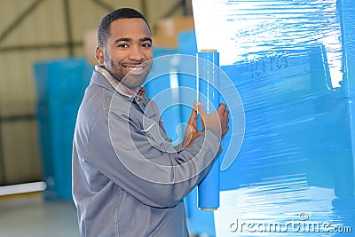Man plastic wrapping goods at warehouse Stock Photo