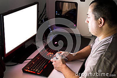 Man playing computer game on custom made desktop with joypad, ke Stock Photo