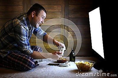 Man playing on a console on the joystick before the big TV Stock Photo