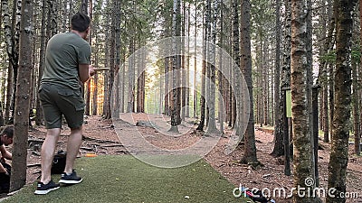 Man playing disc golf in the forest in Norway with a beautiful landscape Stock Photo