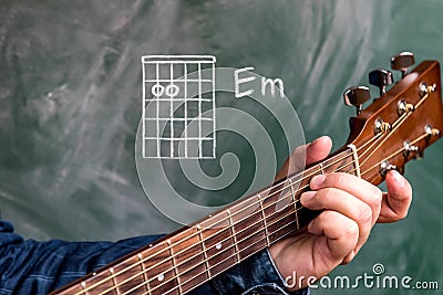 Man playing guitar chords displayed on a blackboard, Chord E minor Stock Photo