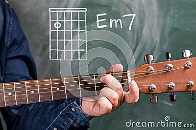 Man playing guitar chords displayed on a blackboard, Chord Em7 Stock Photo