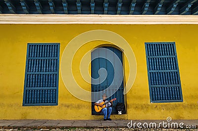 Man playing the guitar in front of one of the colonial buildings Editorial Stock Photo