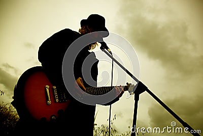 Man playing guitar outdoors Stock Photo