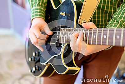 Man playing guitar on a stage. Musical concert. Close-up view Stock Photo