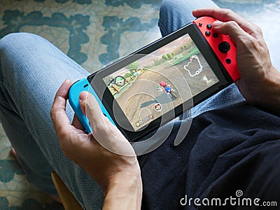 A man playing Mario Kart 8 Deluxe on Nintendo Switch. Editorial Stock Photo