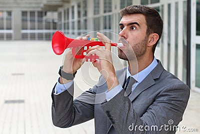 Man playing a plastic trumpet in the office Stock Photo