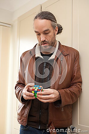 A man playing with a Rubix cube Editorial Stock Photo
