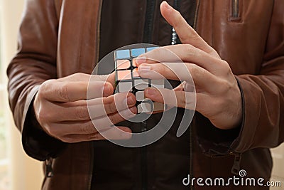 A man playing with a Rubix cube Editorial Stock Photo