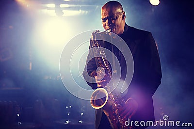 Man Playing Saxophone on Stage Stock Photo