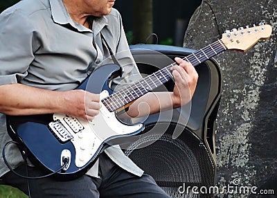 A man plays electric guitar in the street. Street musician Stock Photo