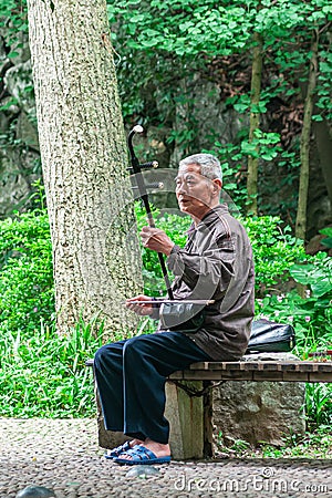 Man plays the erhu or Chinese violin at Seven Star Park, Guilin Editorial Stock Photo