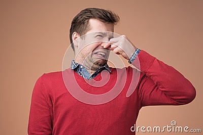 Man plugs nose as smells something stink Stock Photo