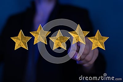 Man pointing at 3D rendering of five stars in a foreground. A concept of ranking for excellence Stock Photo