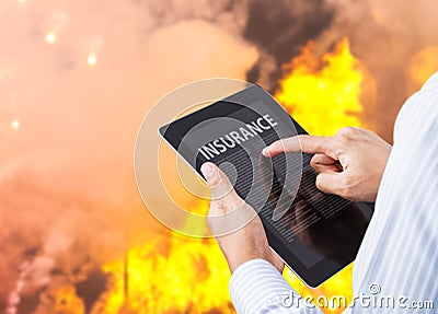 Man pointing at insurance wording on tablet with fire Stock Photo