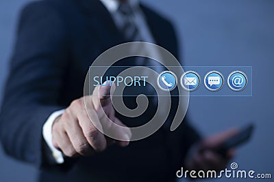 Man pointing support button on virtual screen against dark background, business, technology, internet and networking concept. Stock Photo
