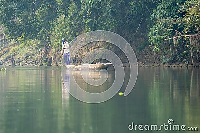 Man Poling a Dugout Canoe Stock Photo